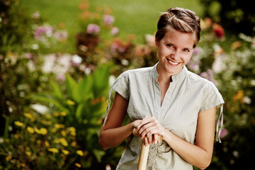 lovely young woman, portrait in the garden with spade
