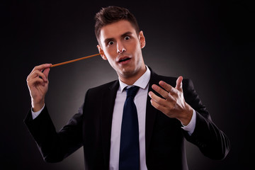 Young conductor sticking his baton in his ear