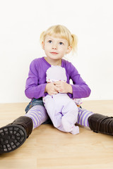 Naklejka premium little girl playing with a doll