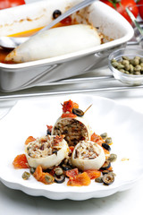 baked sepia with tomatoes and black olives filled with pearl bar