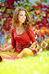 Student smiling against a autumn leaves  background