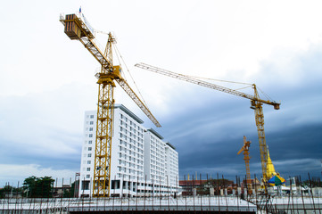 Construction site with crane near building on Cloudy storm backg