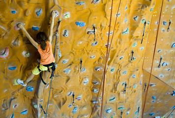 Climbing teenager girl to the top of wall