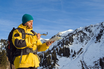 Climbing young adult with map and compass