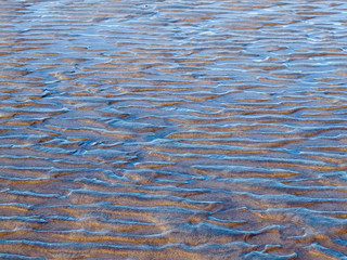 Ocean Ripples and Sand in Shallow Water on a Beach