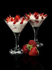 Strawberry with cream in two glasses.