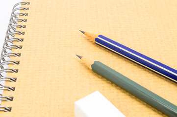 Two Wooden pencil and eraser on recycle notebook on white backgr