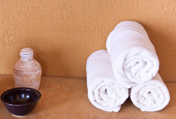 Obraz na płótnie Canvas serviettes enroulées et huile de massage