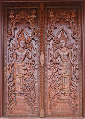 Fototapeta na wymiar Native Thai style carving, painting on church door in the temple