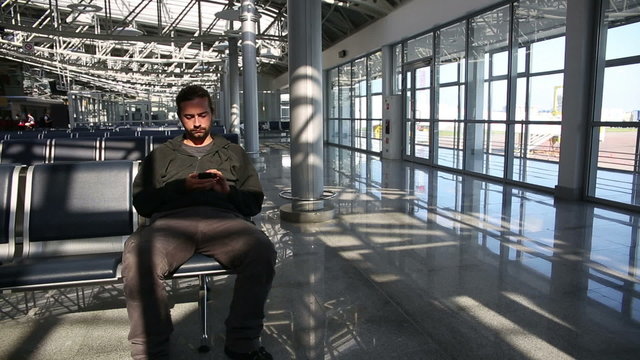 young man waiting his flight in airport lounge