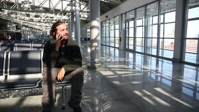 young man talking on phone at airport