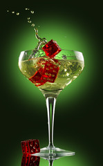 champagne glass and dice over green background