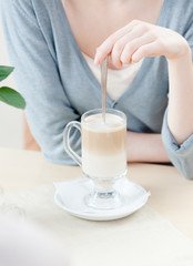 Woman is stirring the cocktail at the cafe