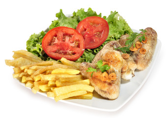 Alitas de pollo con ensalada y patatas.