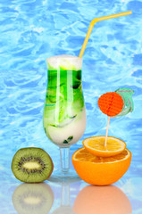 Delicious milk shake with fruit on blue sea background
