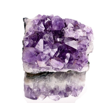 purple rough amethyst crystals isolated on white .