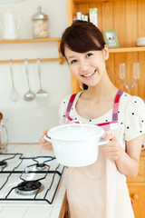 Beautiful young woman in the kitchen. Portrait of asian.