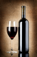 Wine bottle and wineglass on a old canvas