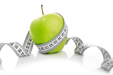 Measuring tape wrapped around a green apple