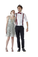 Teen couple in party clothes hug and laugh.