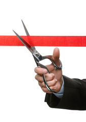 A business man cutting a satin ribbon with scissors