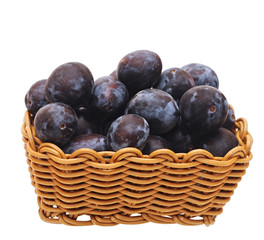 a basket with plums on white background