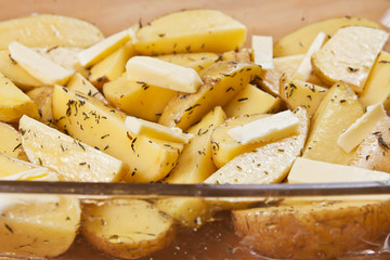 Raw potatoes in a glass tray, ready to be roasted