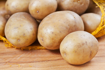 Fototapeta premium Raw potatoes in a yellow net sack