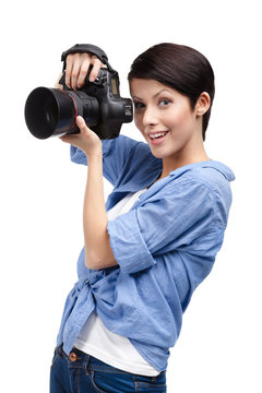 Lady takes photos holding photographic camera, isolated on white