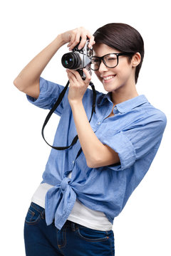 Woman in spectacles makes photos with retro photographic camera