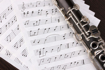 Musical notes and clarinet on wooden table