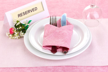 Table setting with reserved card in restaurant