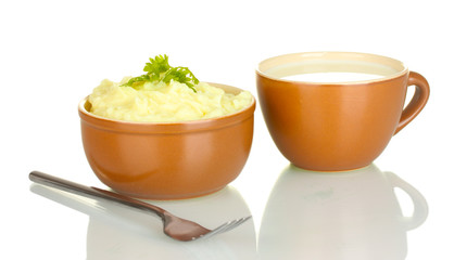Mashed potato with parsley in the bowl and cup with milk