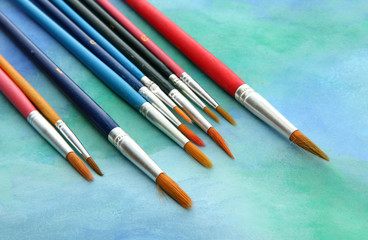 brushes on bright abstract gouache painted background