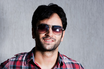 Obraz premium close up of a man wearing sunglasses against grey wall