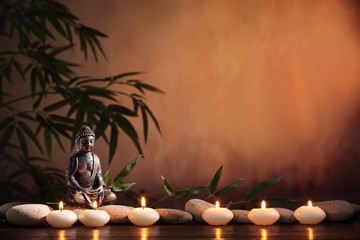 Buddha with burning candle and bamboo