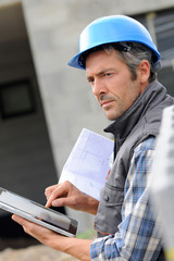 Entrepreneur on construction site using electronic tablet