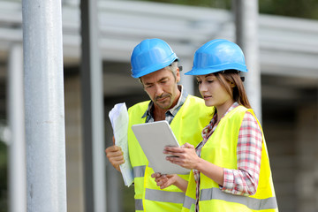 Construction people using electronic tablet on site