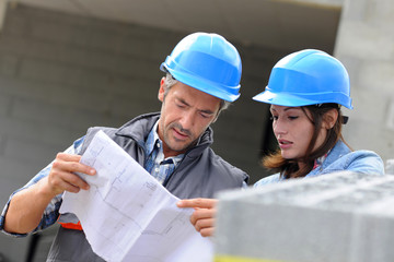 Closeup of engineers reading plan on building site