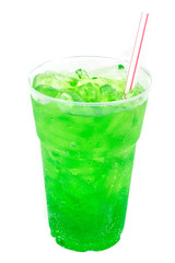 Green soda and ice on the plastic grass
