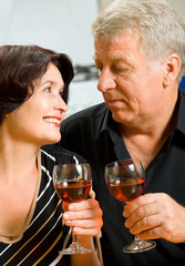 Cheerful senior couple toasting with redwine
