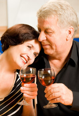 Cheerful senior couple toasting with redwine
