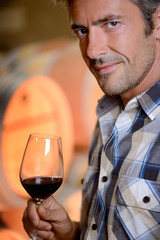 Closeup on winemaker smelling red wine in glass
