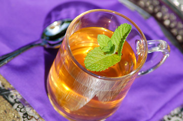 cup of herbal tea with fresh leafs of mint close up