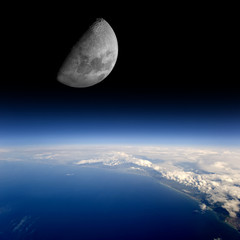 The Moon rises over planet Earth.