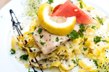 close-up of plate of pasta and smoked salmon with tomato