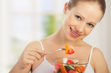 young healthy woman eats vegetable salad