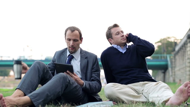 Two businessmen relaxnig in the city park