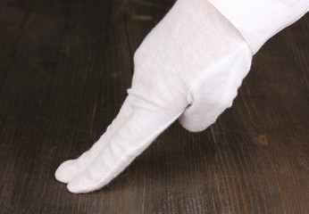 Female hand checking cleanliness on wooden background