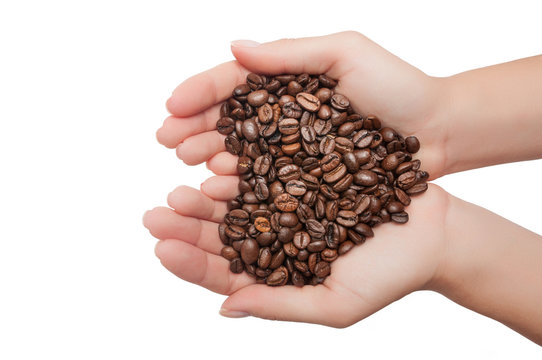 Heart shape made from coffee beans in hands